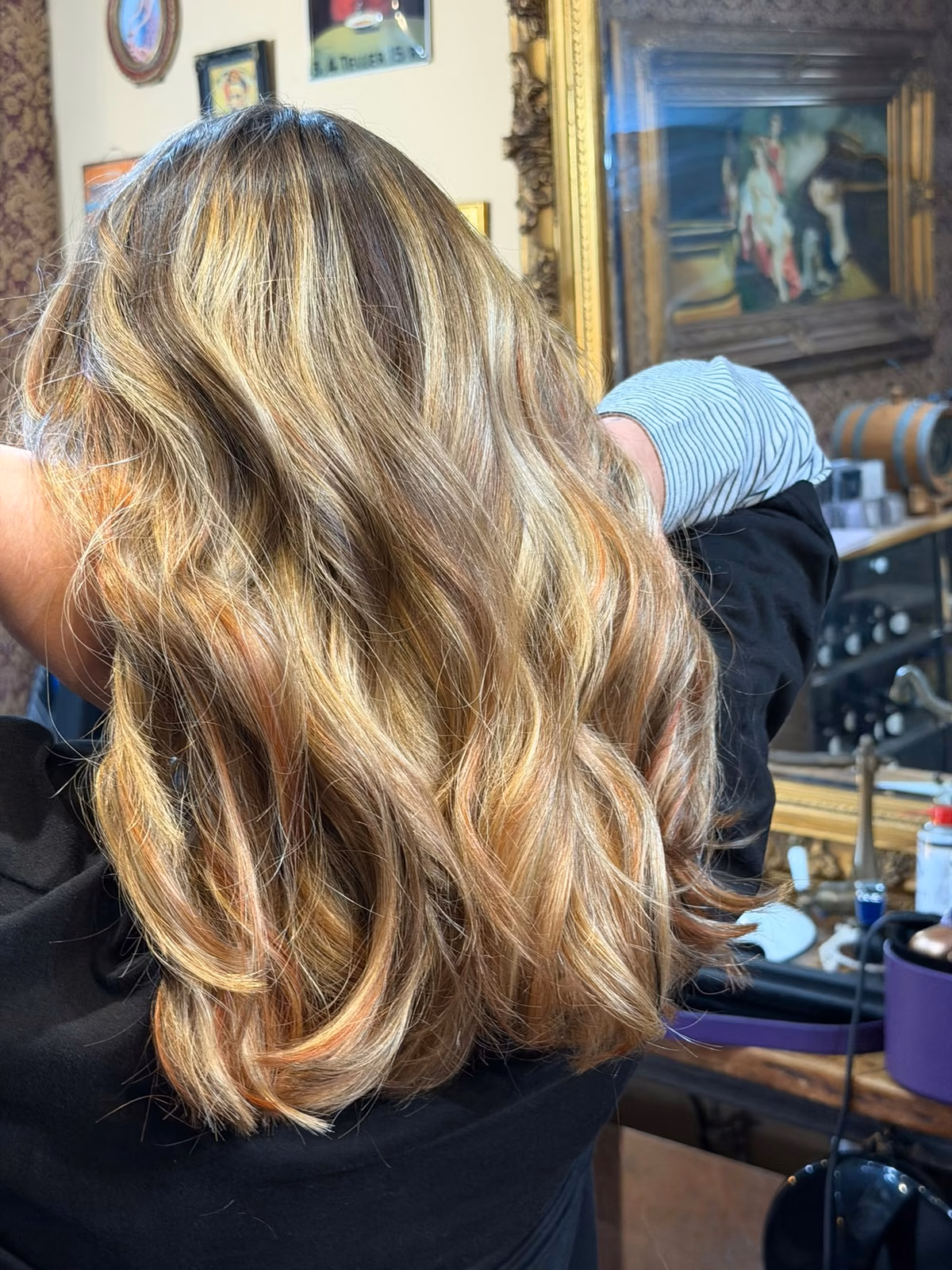 Karamell-blonde Balayage mit Wellen in der Seitenansicht